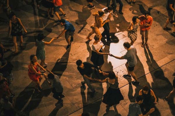 A top-down photo of a couples dancing in a public square at night.